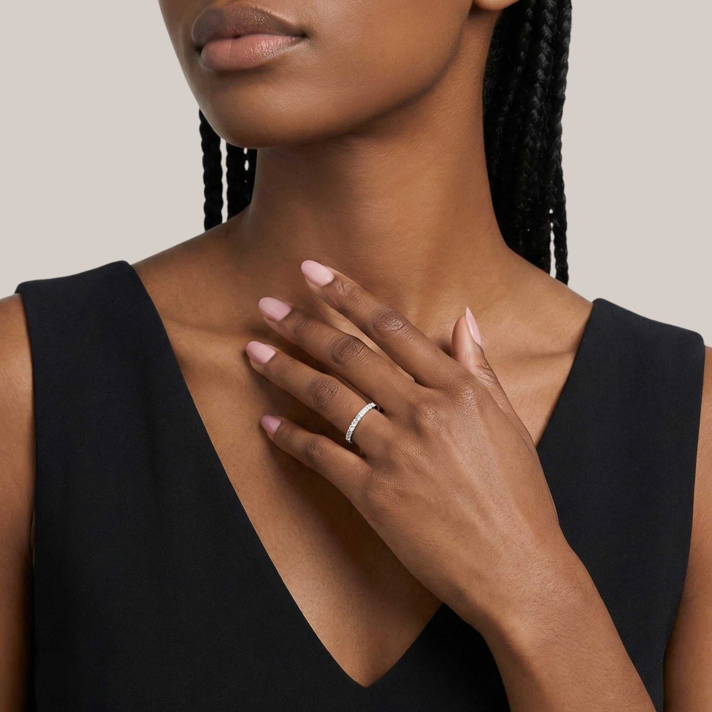 Woman wearing a black sleeveless top with a close-up of her hand and ring.