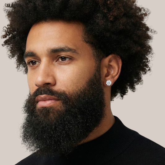 Man with a beard wearing a diamond earring against a neutral background
