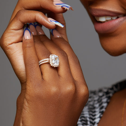 Close-up of a hand wearing a diamond ring with a blurred background
