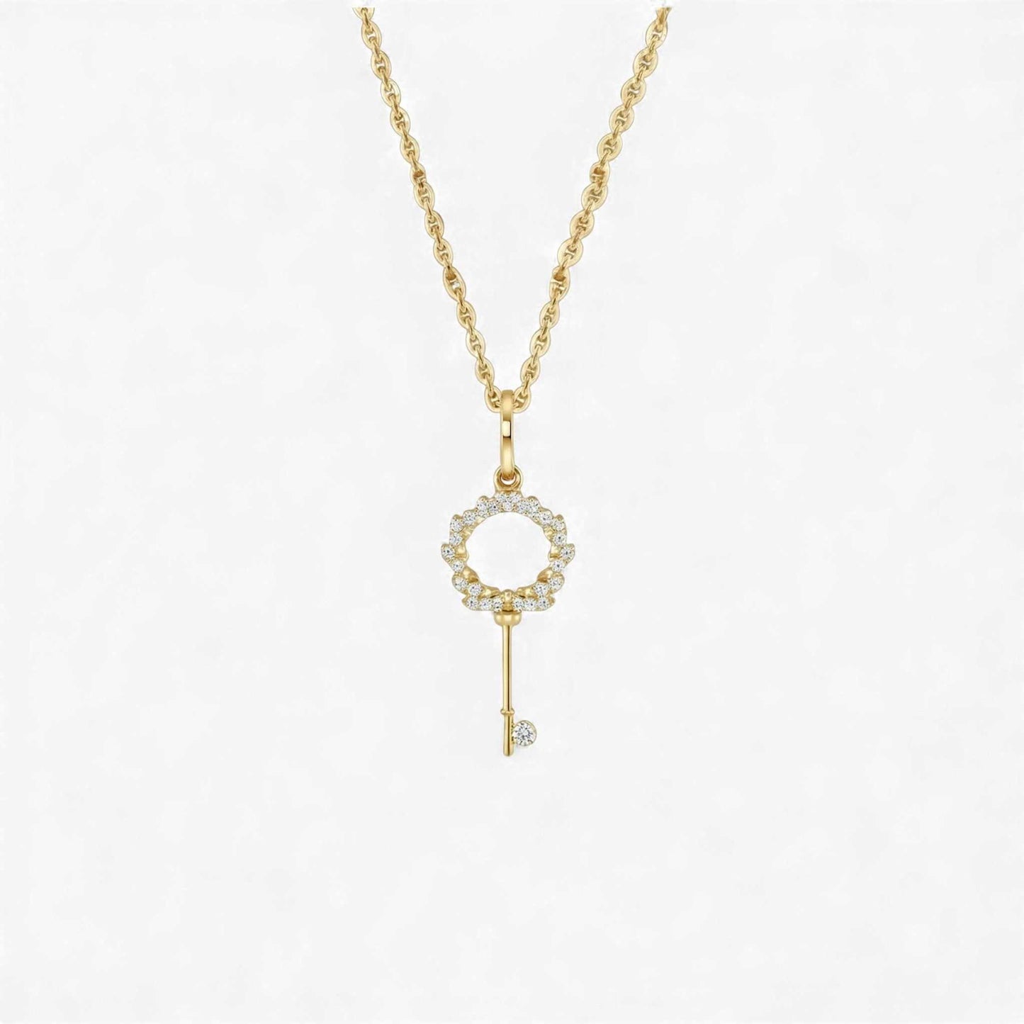 Gold key-shaped pendant necklace on a white background