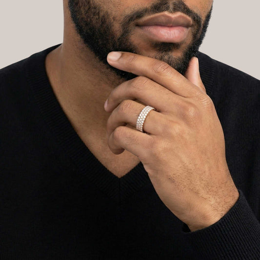 Man wearing a silver ring on his finger with a neutral background