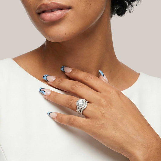 Close-up of a hand wearing a diamond ring with a neutral background