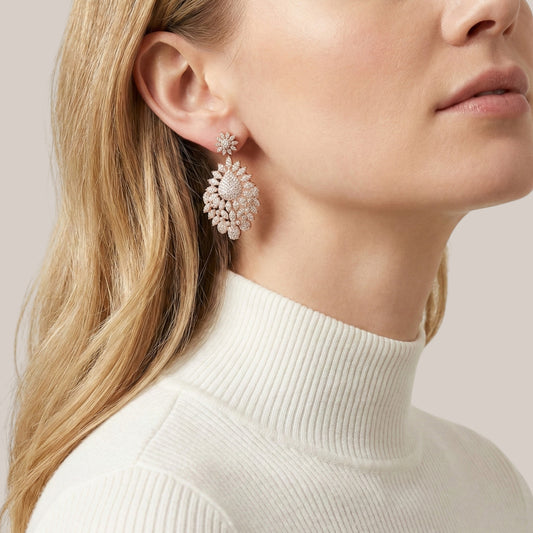 Close-up of a woman wearing a pair of earrings with a neutral background