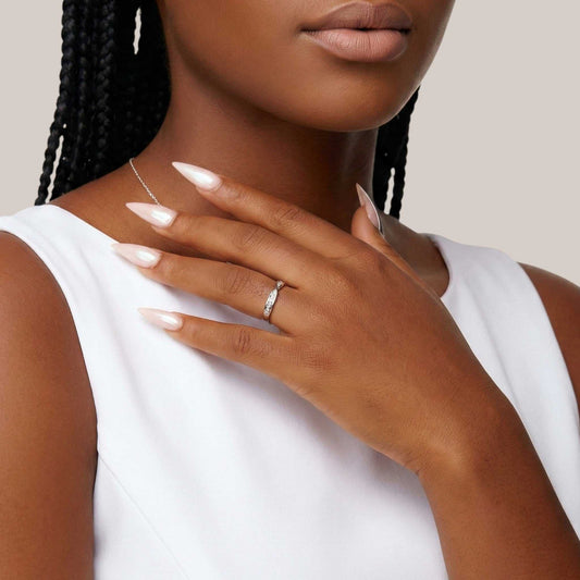 Close-up of a woman's hand with a ring on a neutral background