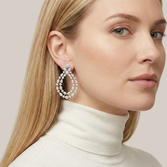 Close-up of a woman wearing a pair of earrings with a neutral background