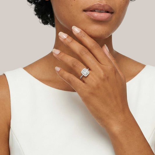 Woman wearing a diamond ring on a plain background
