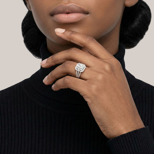 Close-up of a hand wearing a silver ring with a beige background