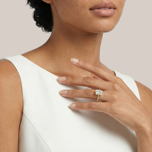 Woman wearing a diamond ring on her hand against a neutral background