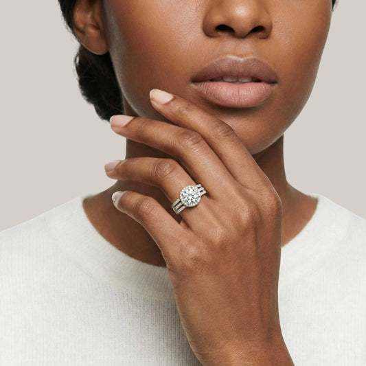 Woman wearing a diamond ring on her finger against a neutral background