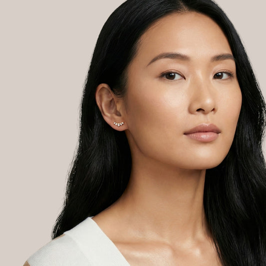 Woman wearing a white top against a beige background