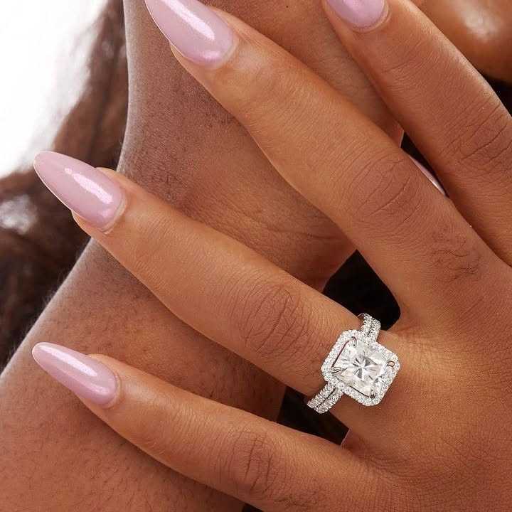 A close-up image of a person's hand wearing a Mia Princess Cut Moissanite Engagement Ring in 925 Sterling Silver, showcasing the ring on the finger.