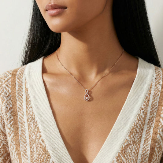 Woman wearing a delicate necklace with a small pendant against a neutral background