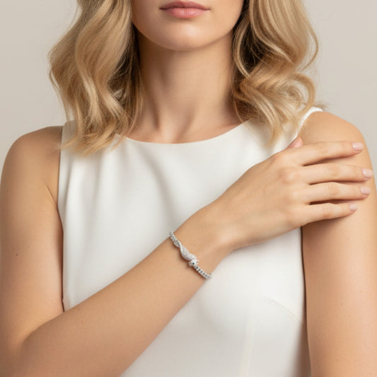 Woman wearing a silver bracelet on a plain background