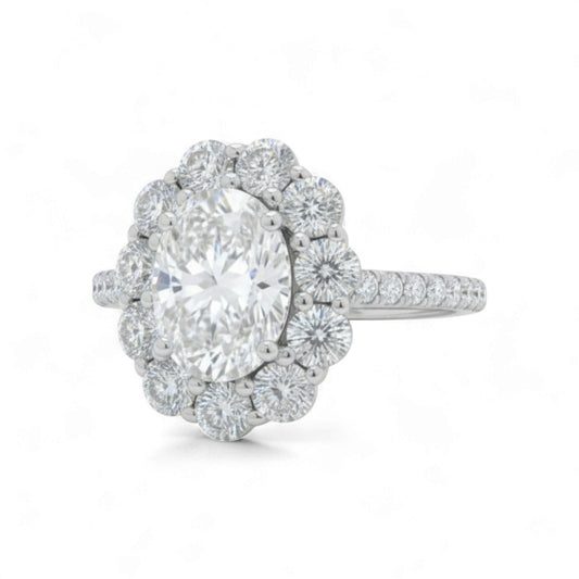 Diamond ring with a large central gemstone and smaller diamonds around on a white background