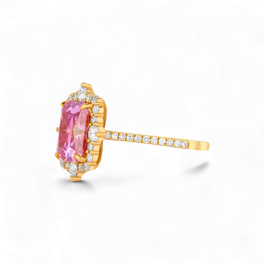 Gold ring with a pink gemstone and diamond accents on a white background