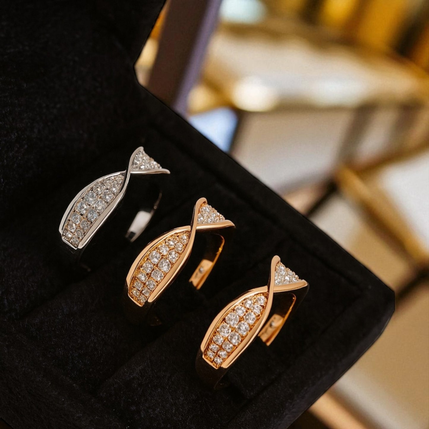 Set of fish-shaped earrings in gold and silver on a black cushion