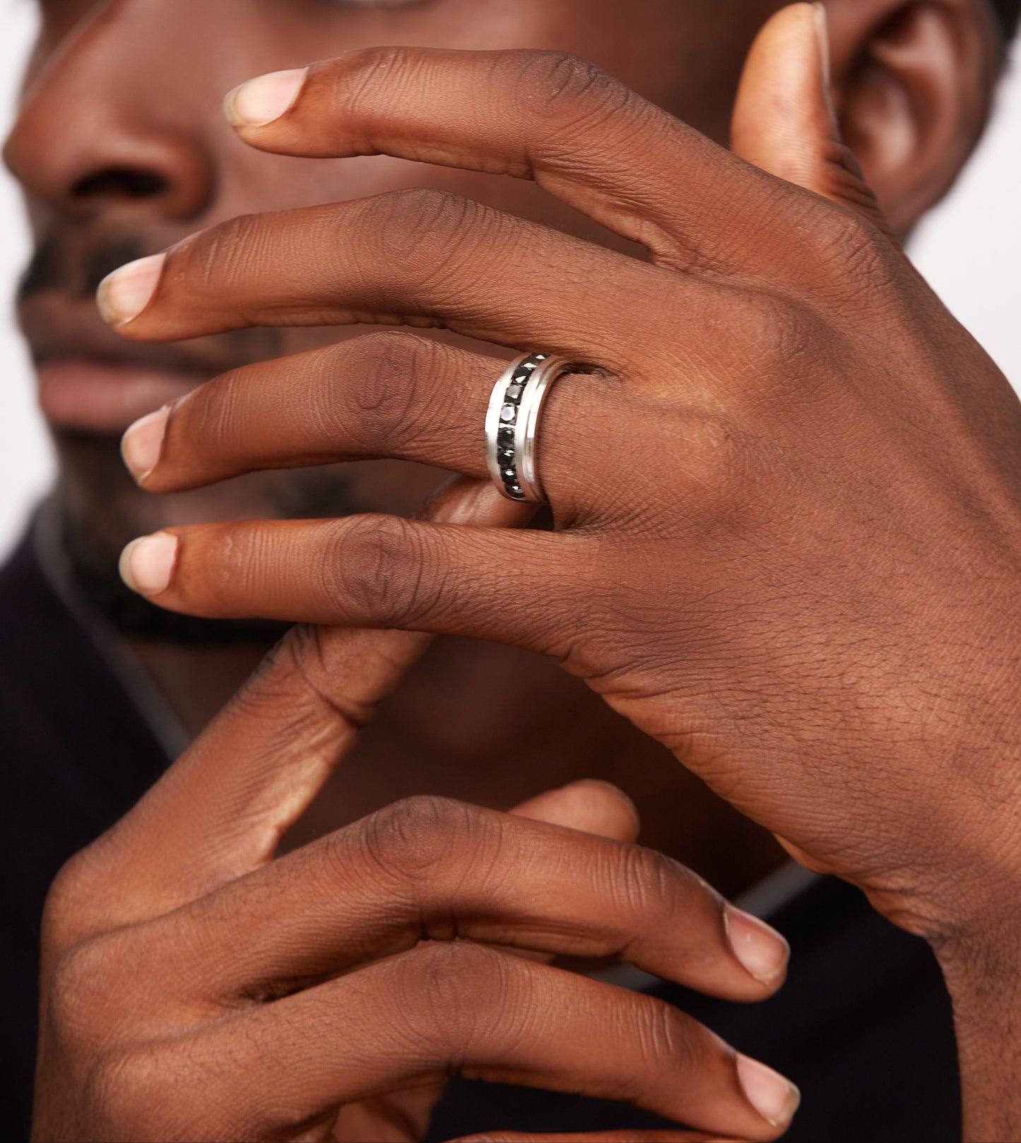 Close-up of a person's hand with a ring, focusing on the hand and ring.