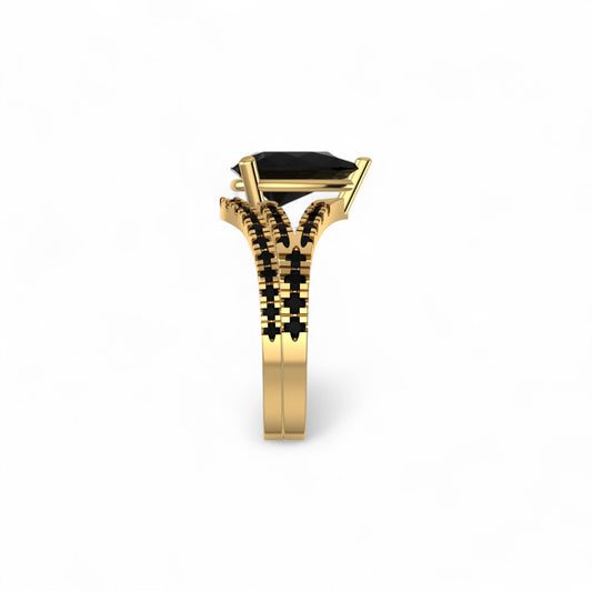 Gold ring with a black gemstone on a white background