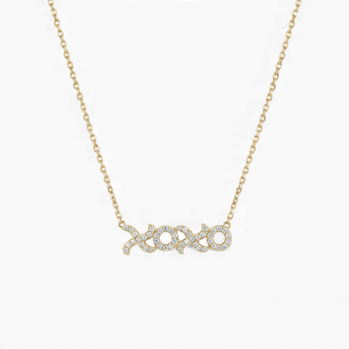Gold necklace with 'xoxo' pendant on a white background