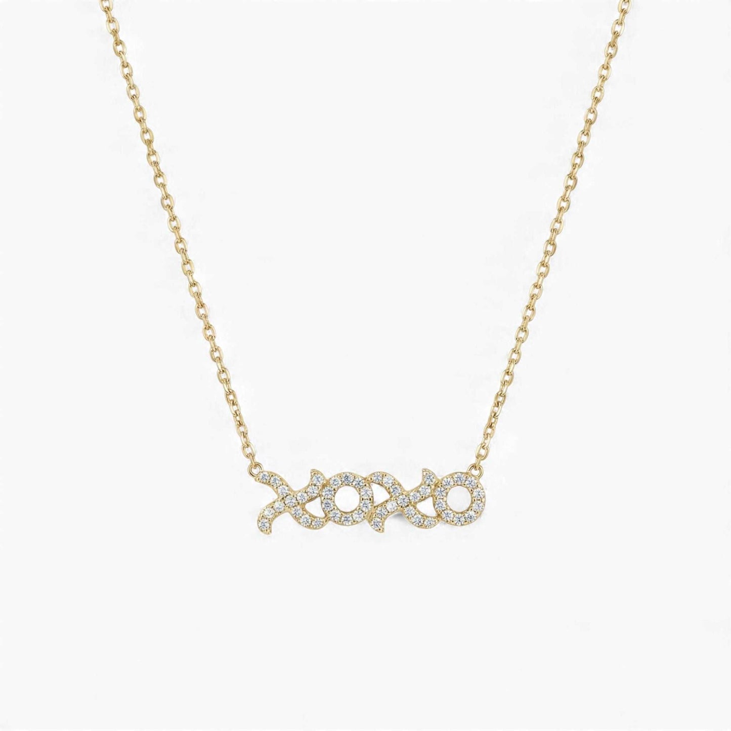 Gold necklace with 'xoxo' pendant on a white background