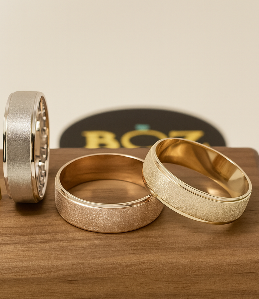 Gold and silver rings on a wooden surface with a blurred background