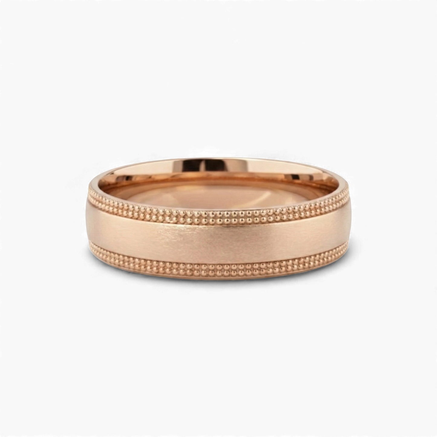 Rose gold ring with milgrain detailing on a white background