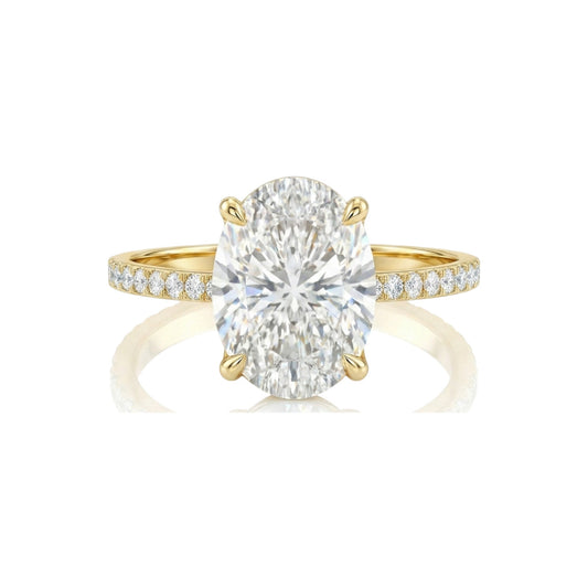 Gold ring with a large diamond and smaller diamonds on the band against a white background