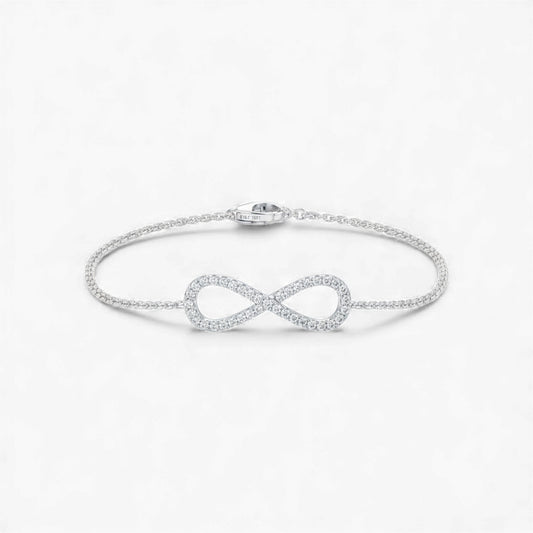Silver infinity bracelet on a light gray background