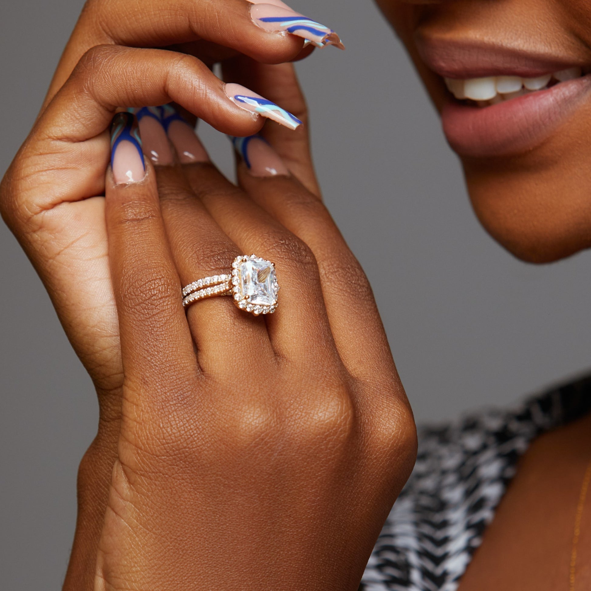 Close-up of a hand wearing a diamond ring with a blurred background
