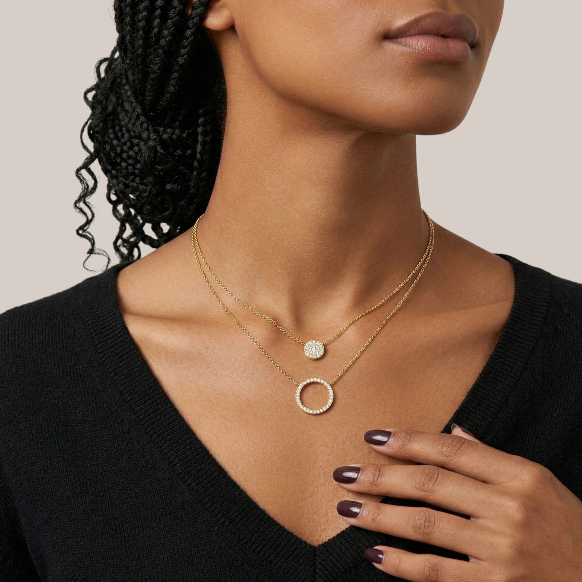 Woman wearing a gold necklace with a plain background