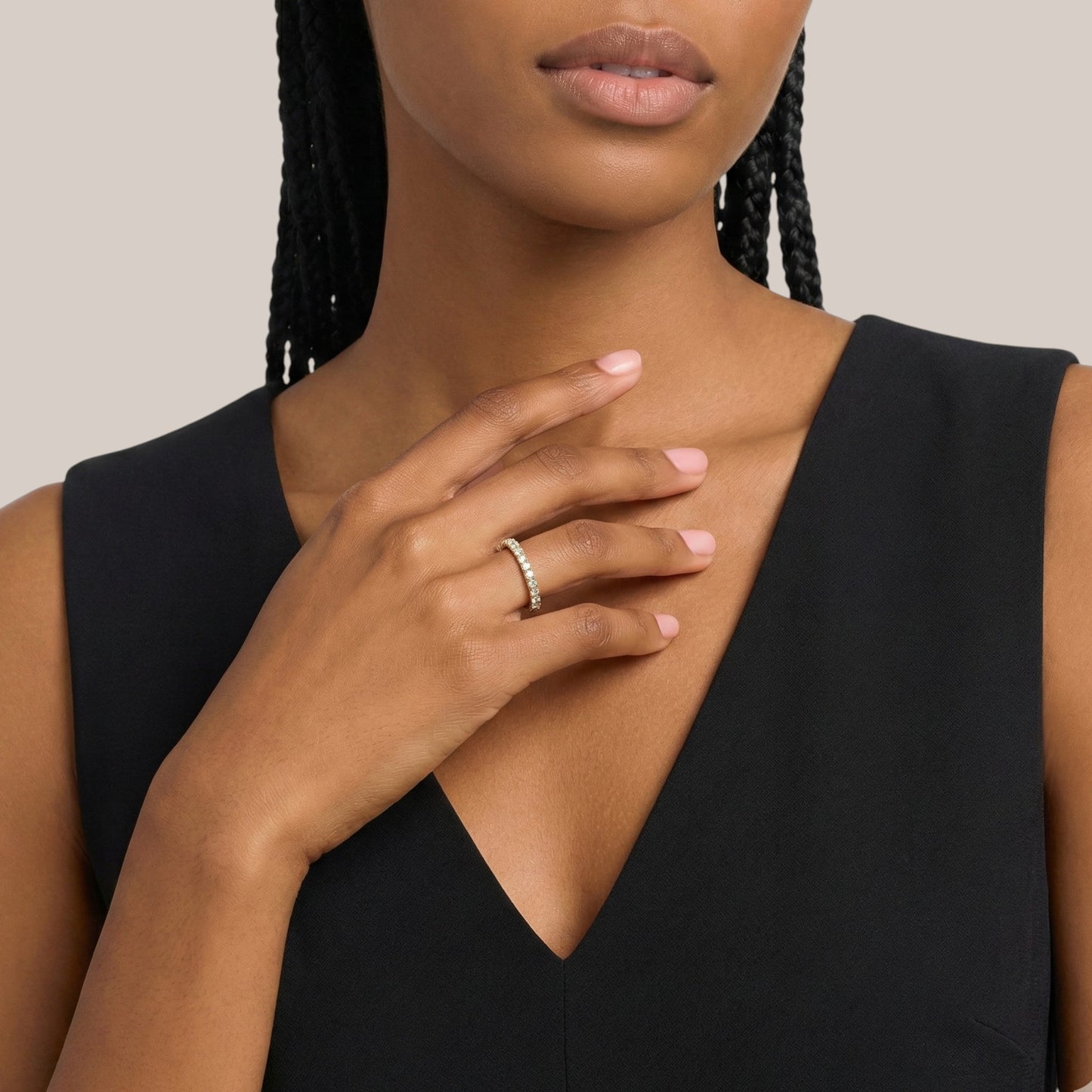 Woman wearing a black sleeveless top with a neutral background