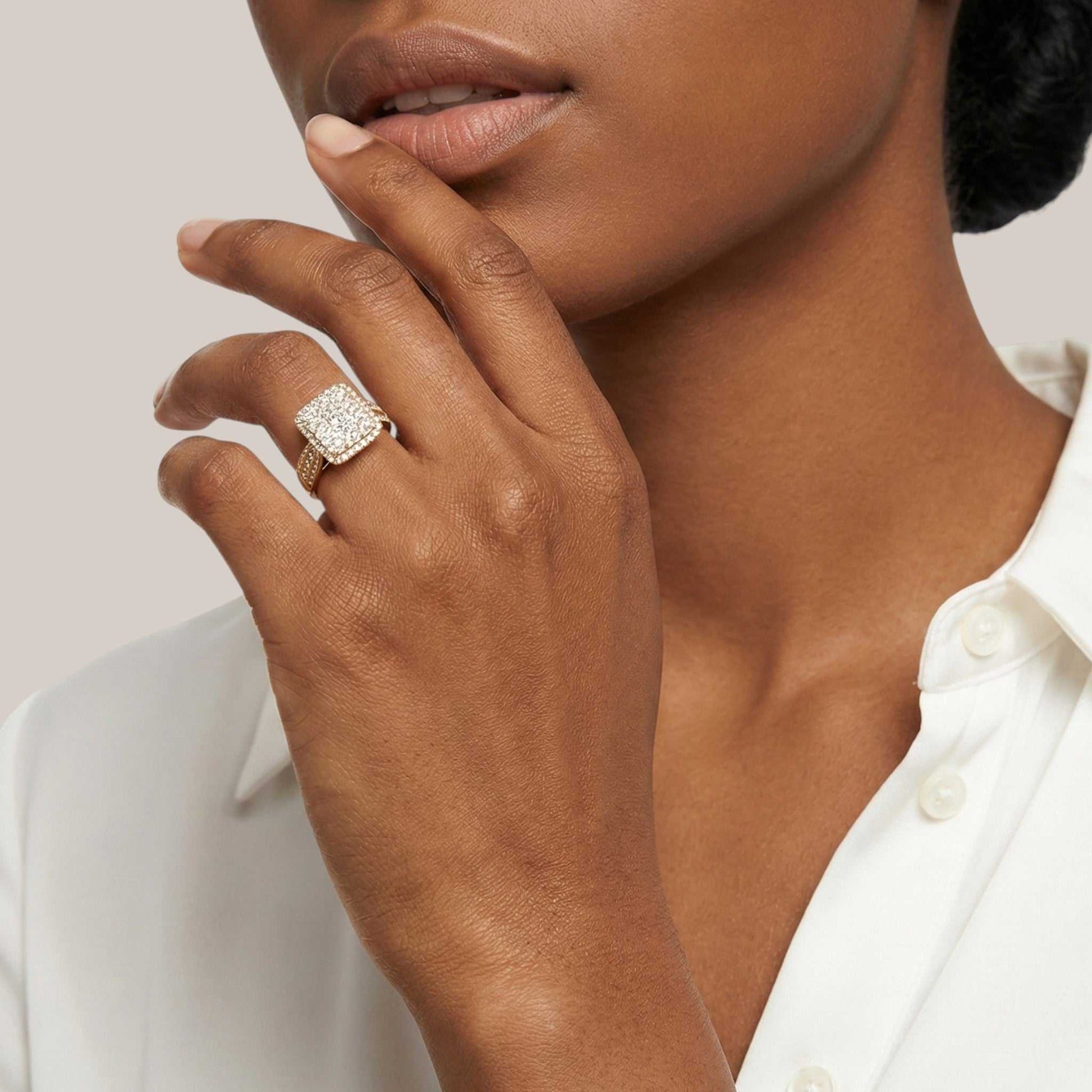Close-up of a woman's hand wearing a diamond ring with a neutral background