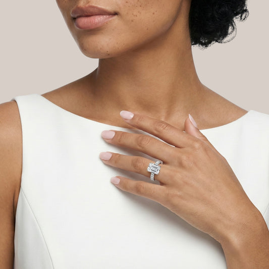 Woman wearing a diamond ring on her hand against a neutral background