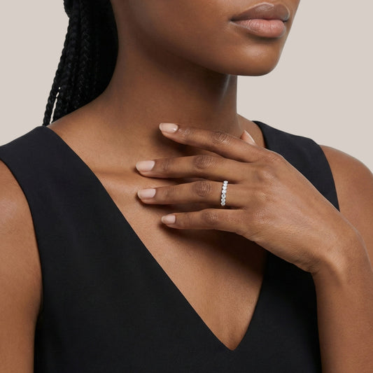 Woman wearing a black sleeveless top with a close-up of her hand and ring.