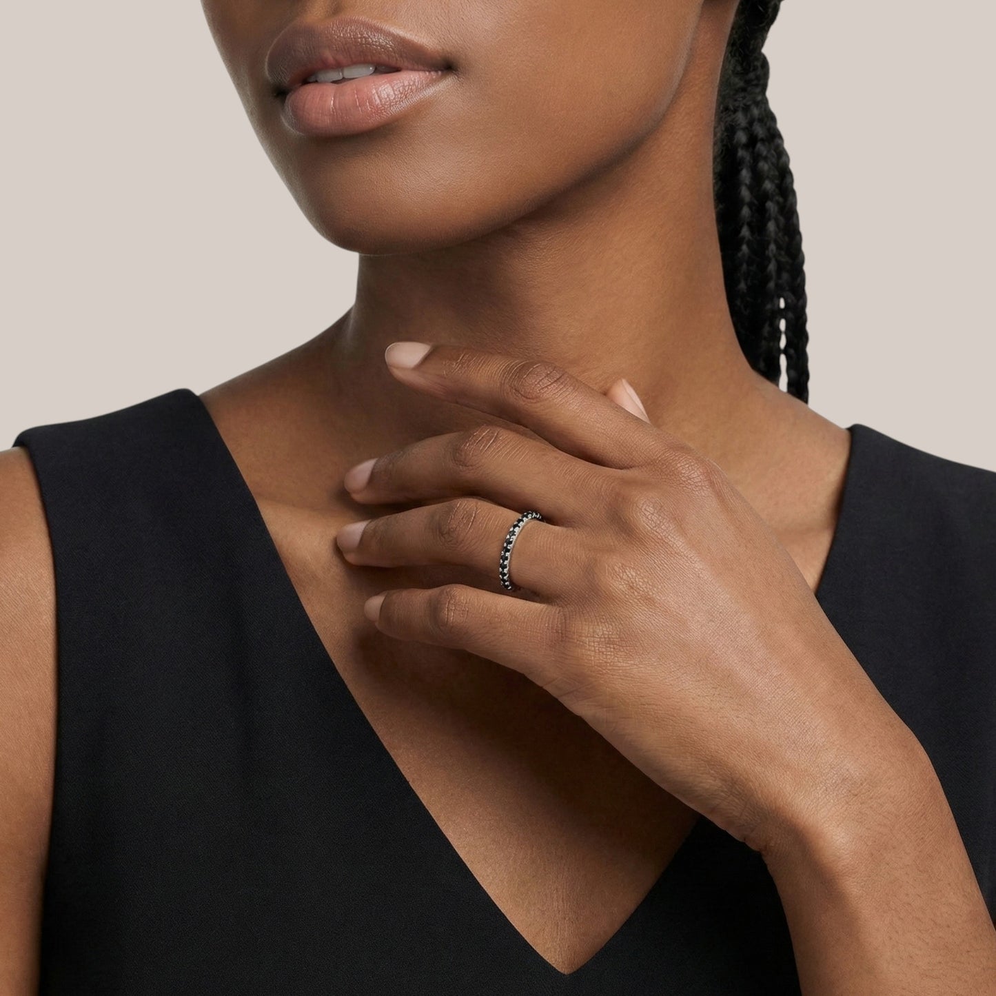 Woman wearing a silver ring on her hand with a neutral background