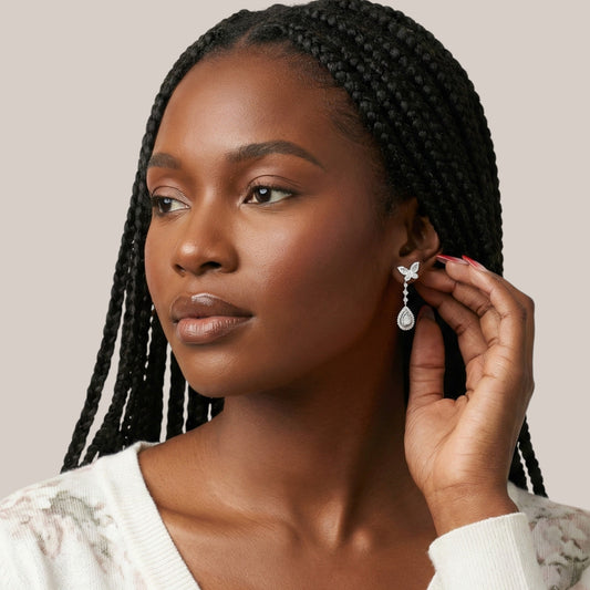 Woman adjusting an earring with a neutral background