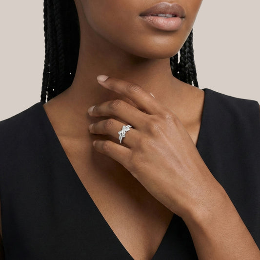Woman wearing a silver ring on her hand with a neutral background