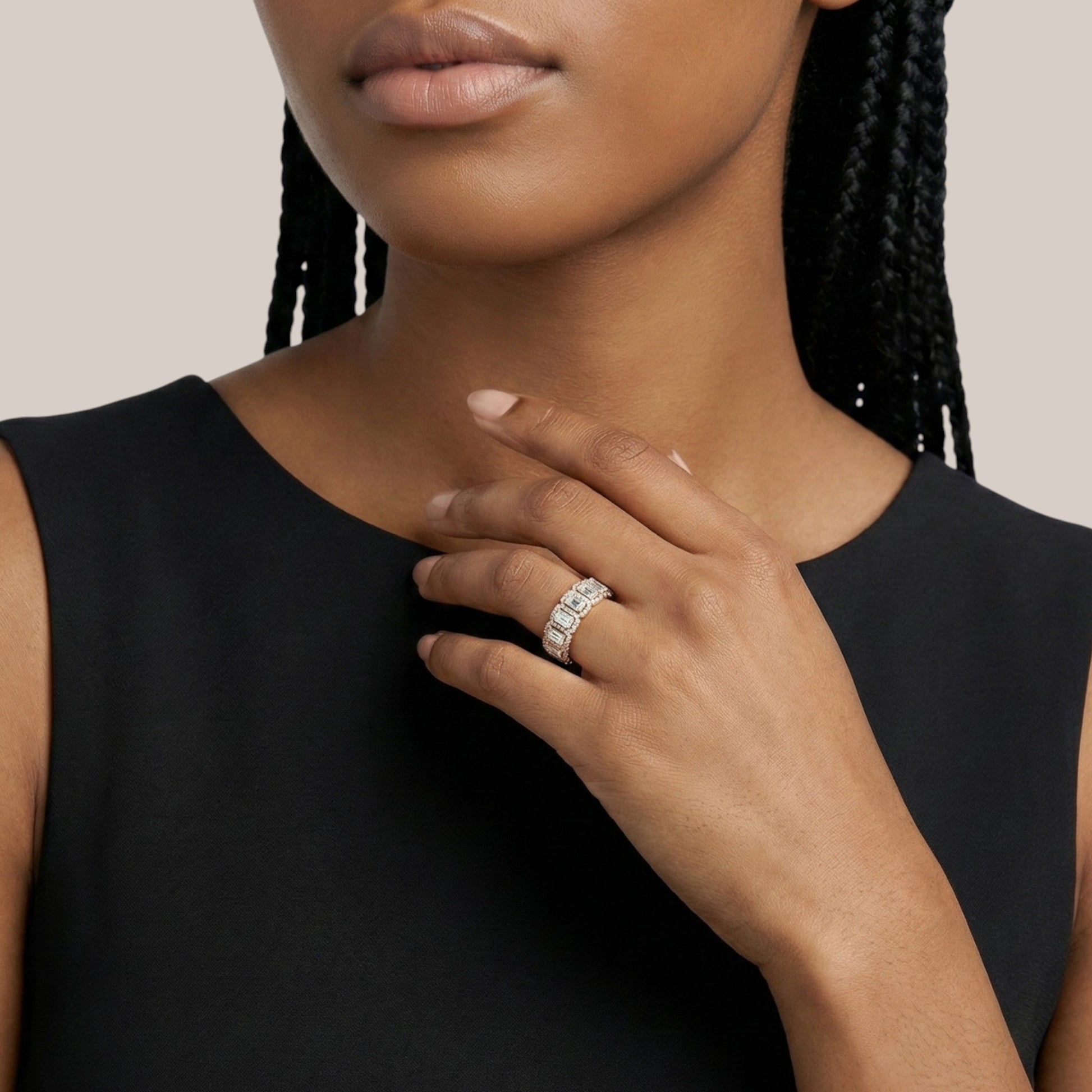 Woman wearing a black sleeveless top with a close-up of her hand and ring.