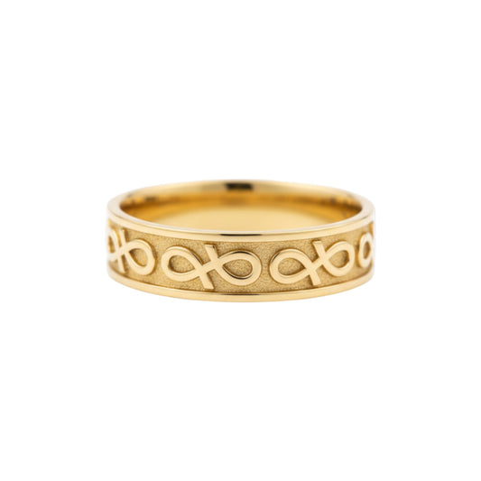 Gold ring with intricate design on a white background