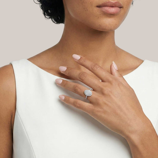 Woman wearing a diamond ring on her hand against a neutral background