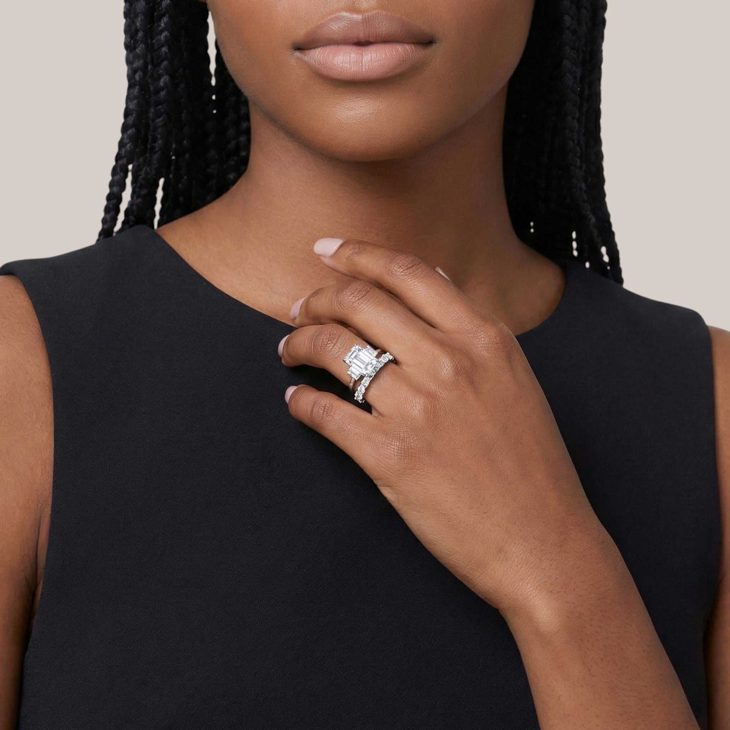 Woman wearing a diamond ring on her hand against a neutral background