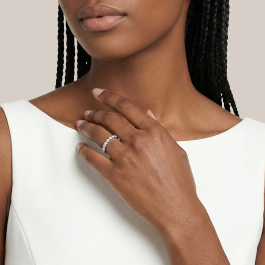 Woman wearing a silver ring on her hand with a plain background