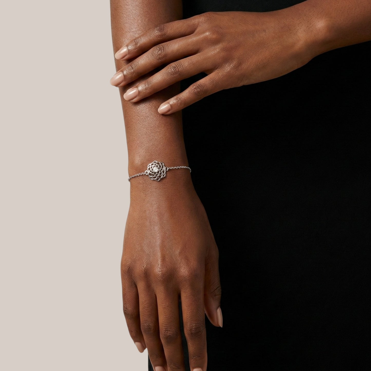 Silver bracelet on a wrist with a neutral background