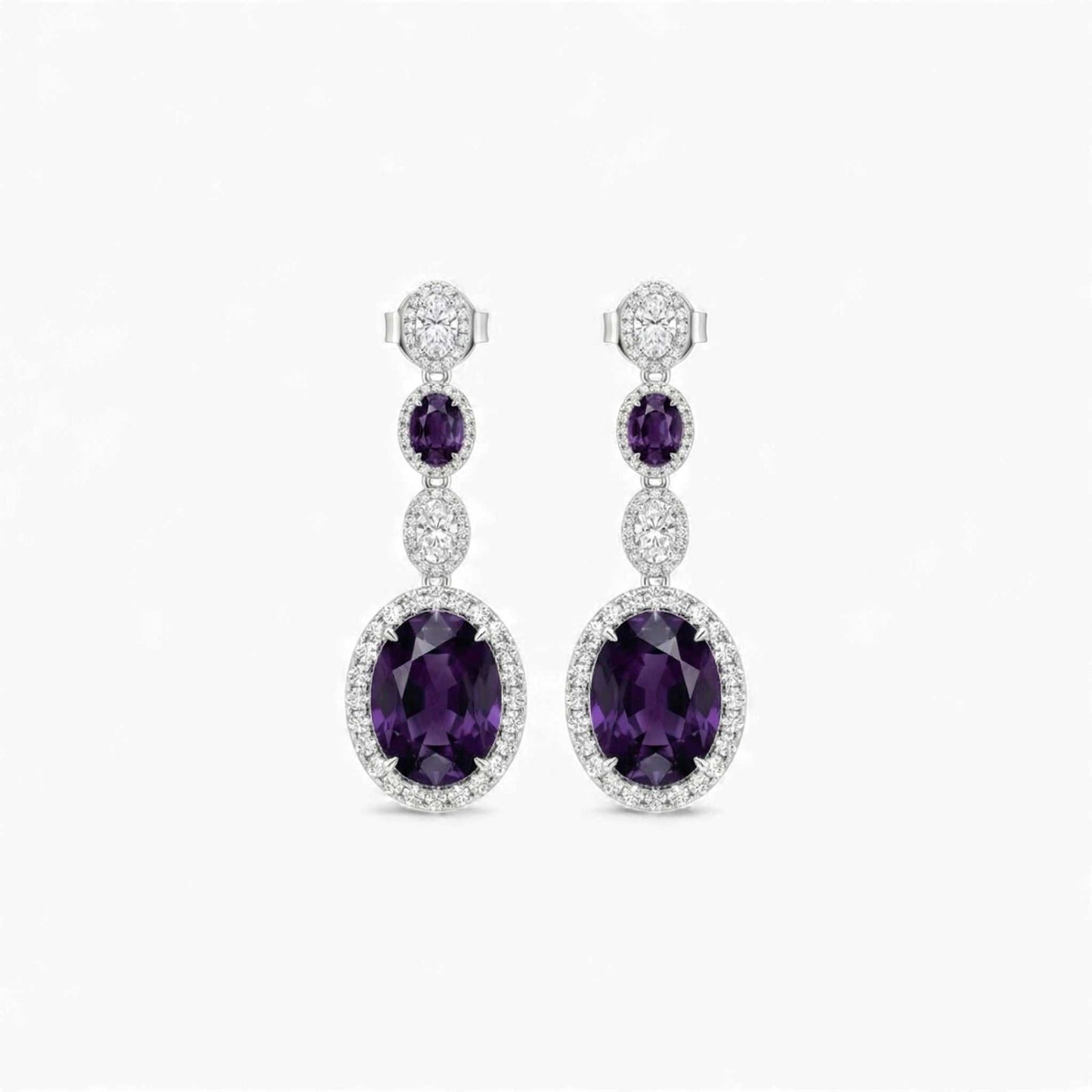 Pair of purple gemstone earrings with silver accents on a white background