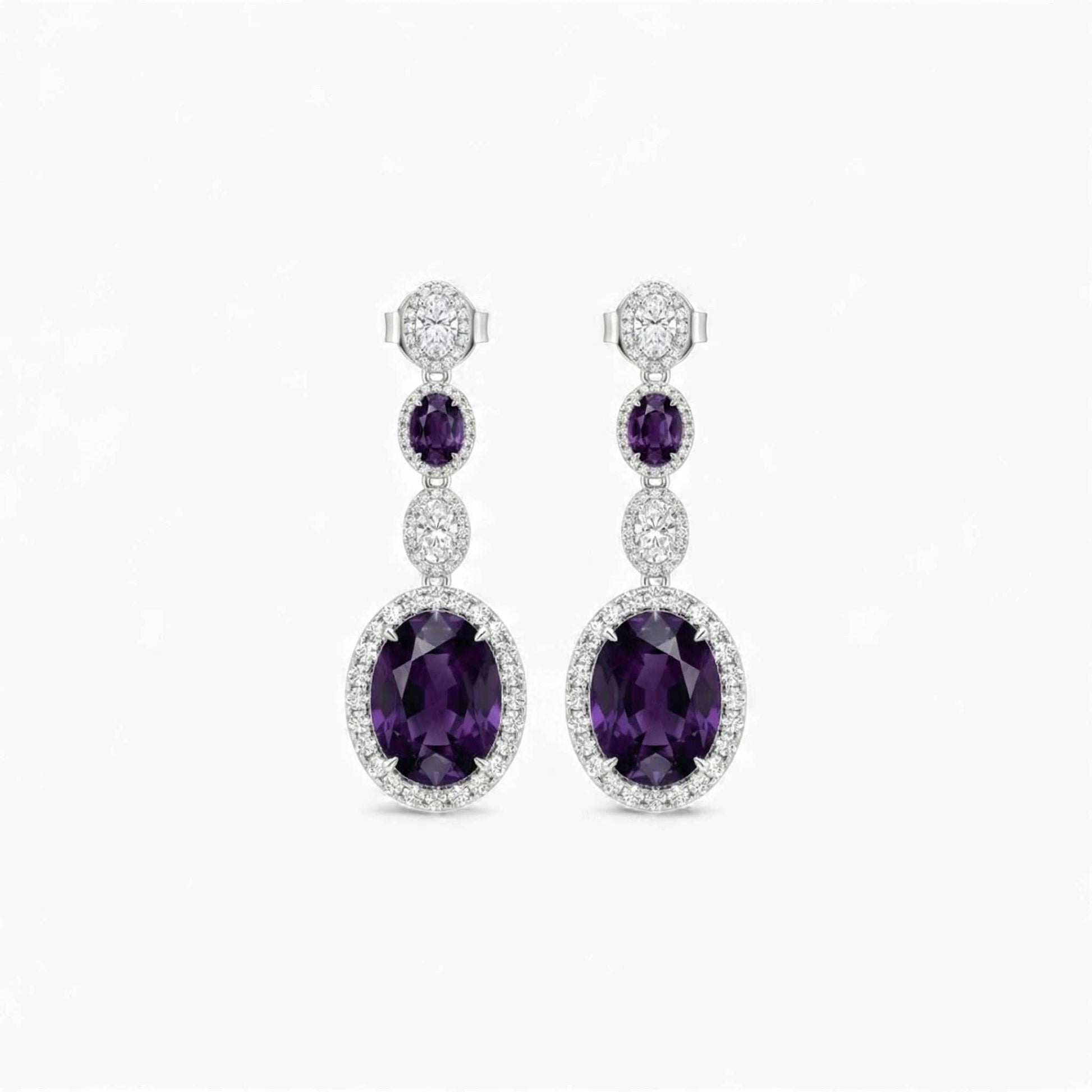 Pair of purple gemstone earrings with silver accents on a white background