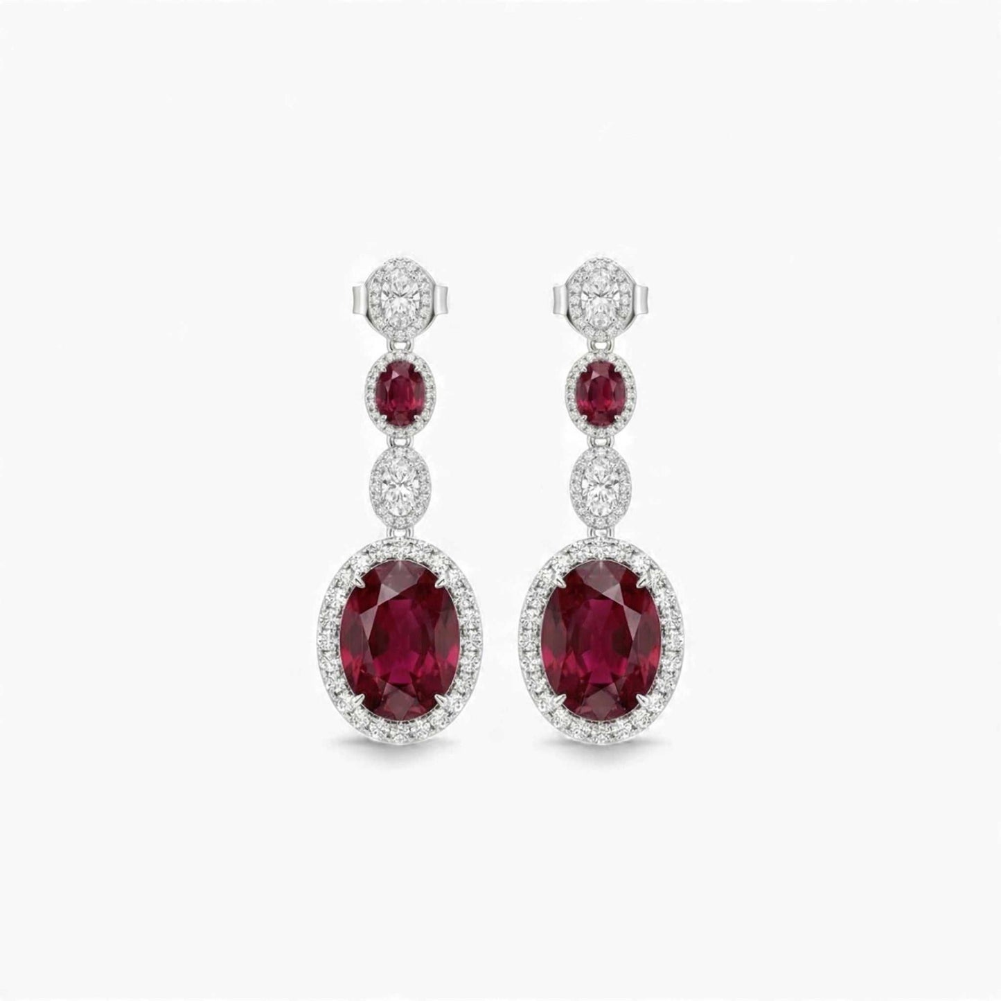Pair of red gemstone earrings with diamond accents on a white background