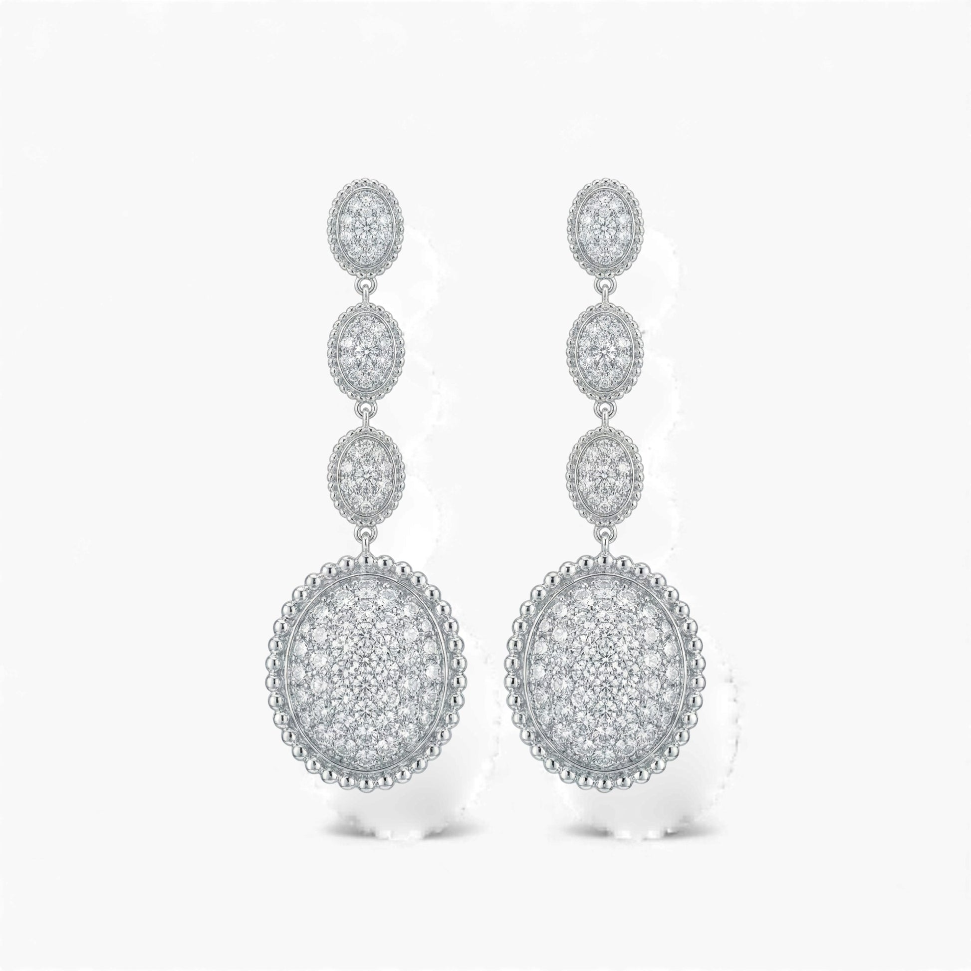 Pair of silver earrings with circular designs on a white background