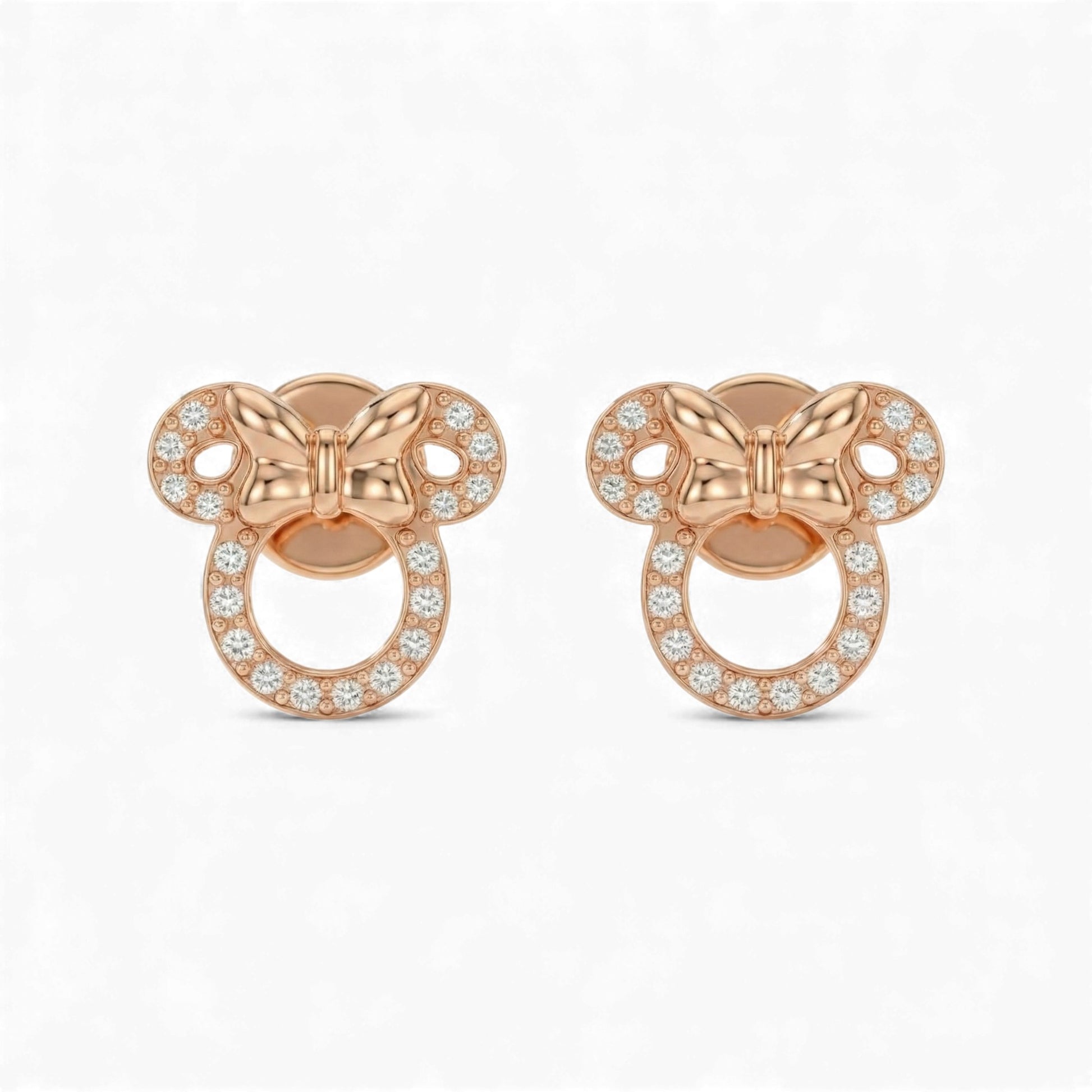 Rose gold butterfly-shaped earrings with clear gemstones on a white background