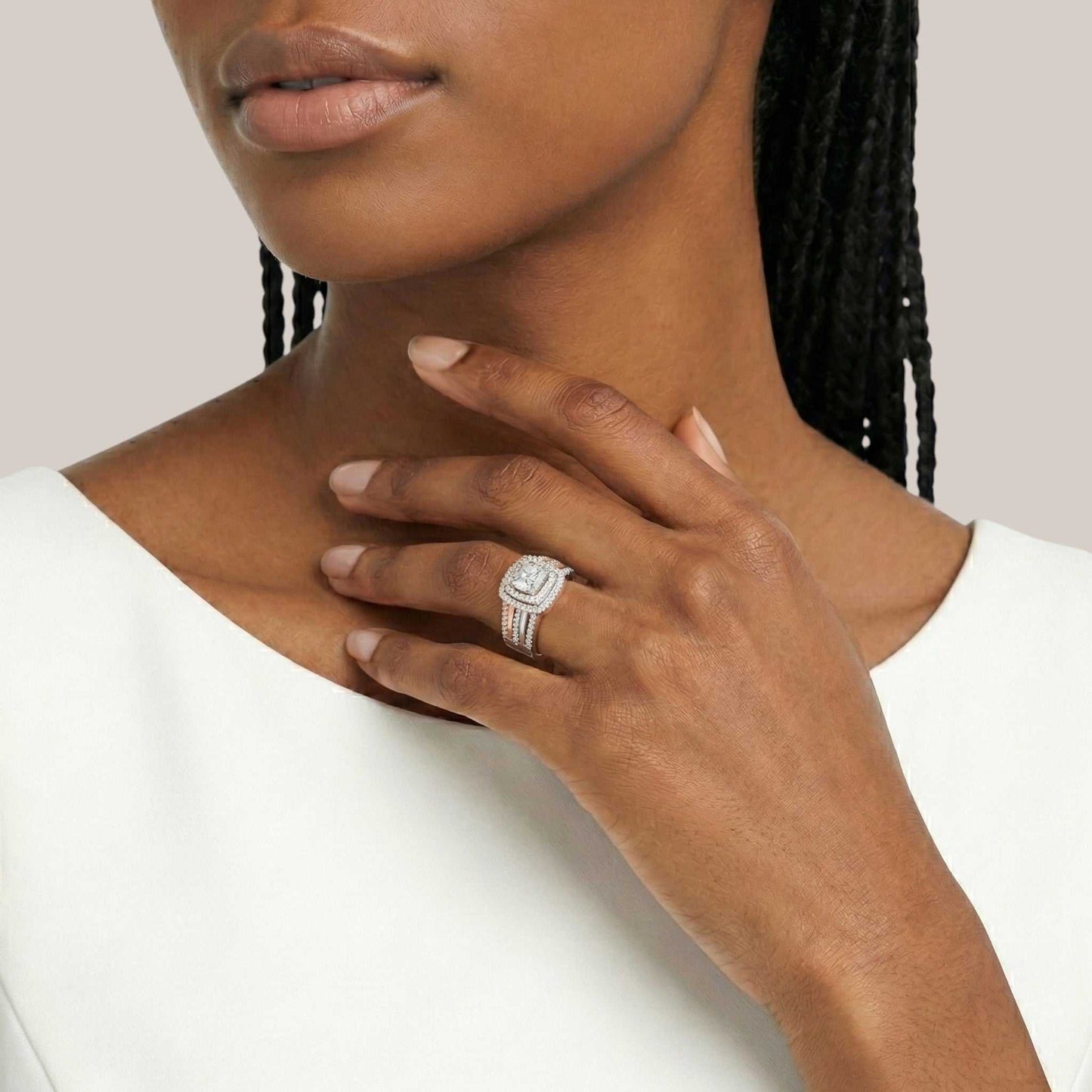 Close-up of a woman wearing a silver ring on her hand with a plain background