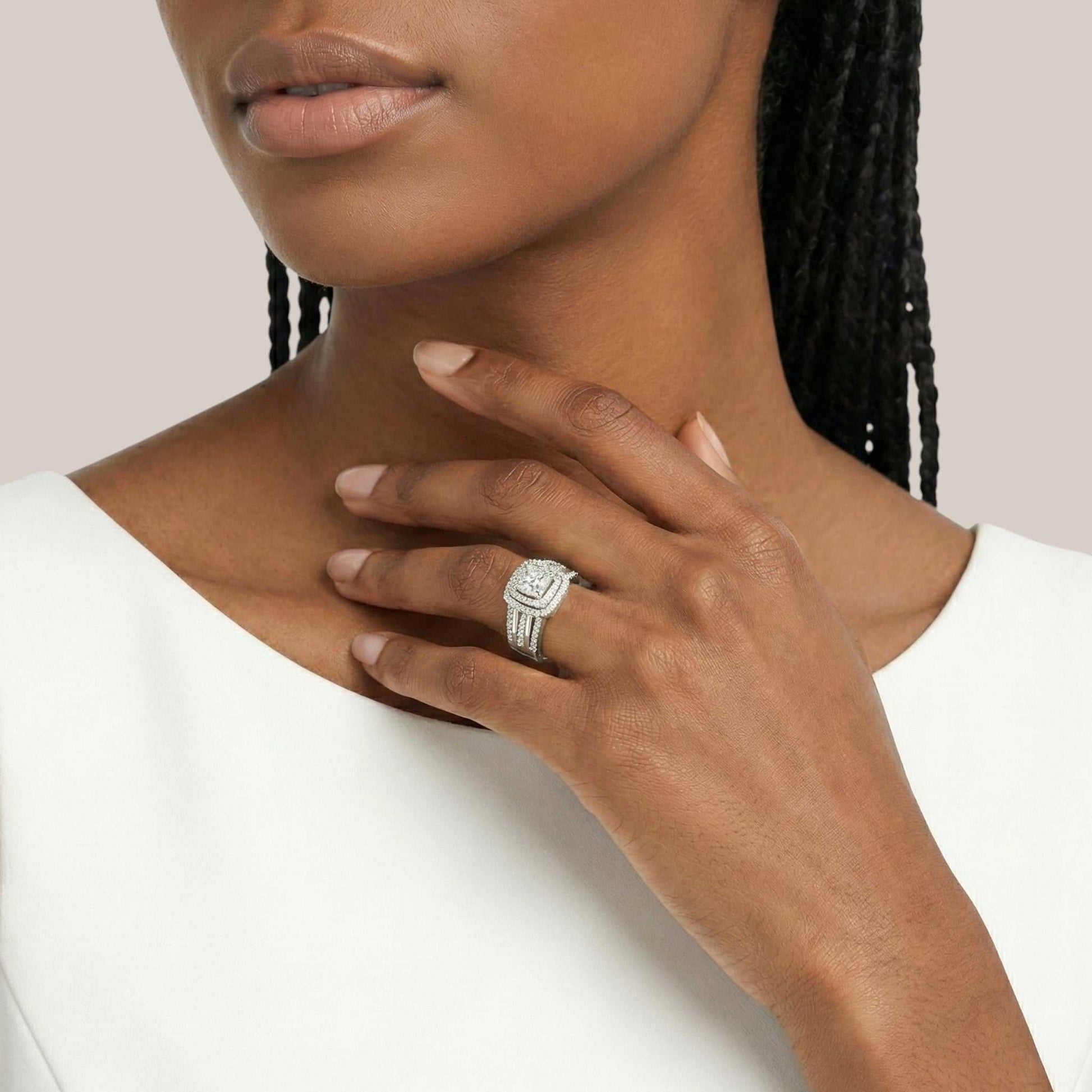 Woman wearing a silver ring with a diamond on a plain background